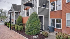Un edificio residencial de varios pisos con fachada gris y detalles de ladrillo.