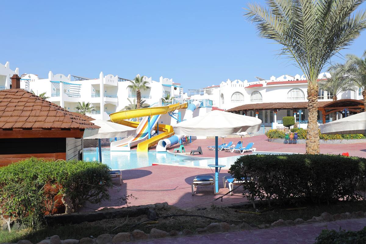 A resort with a water park, including slides and a pool area with lounge chairs.