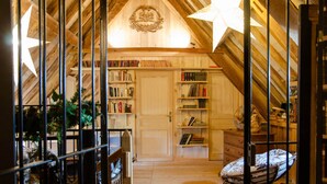Een gezellige zolderkamer met houten balken, een ster decoratie en een boekenplank vol boeken.