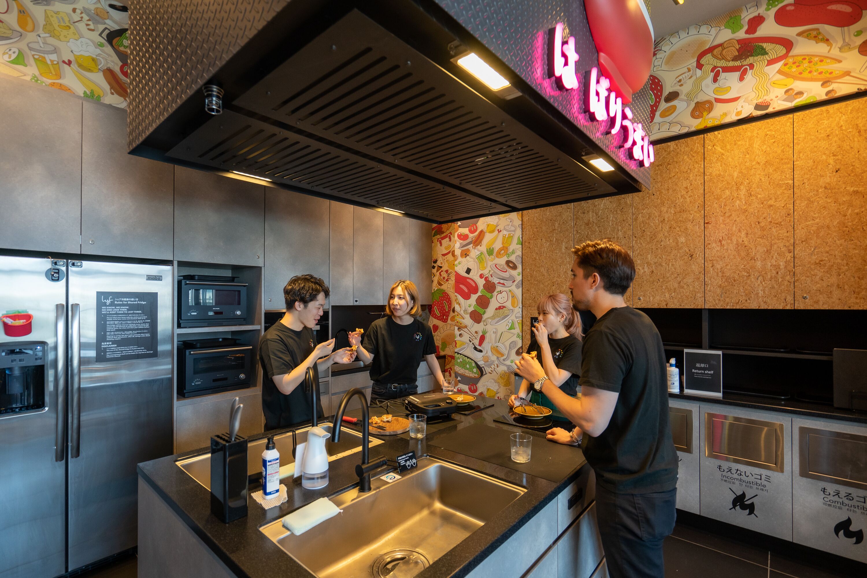 Una cocina moderna con electrodomésticos de acero inoxidable, una isla central y un letrero de neón.
