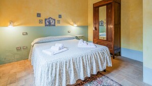 Ein Schlafzimmer mit einem Bett, einem Kleiderschrank und dekorativen Wandfliesen.