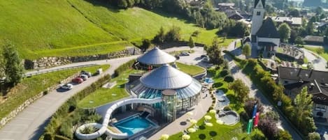 A resort with a pool, a dome-shaped building, and a church in the background.