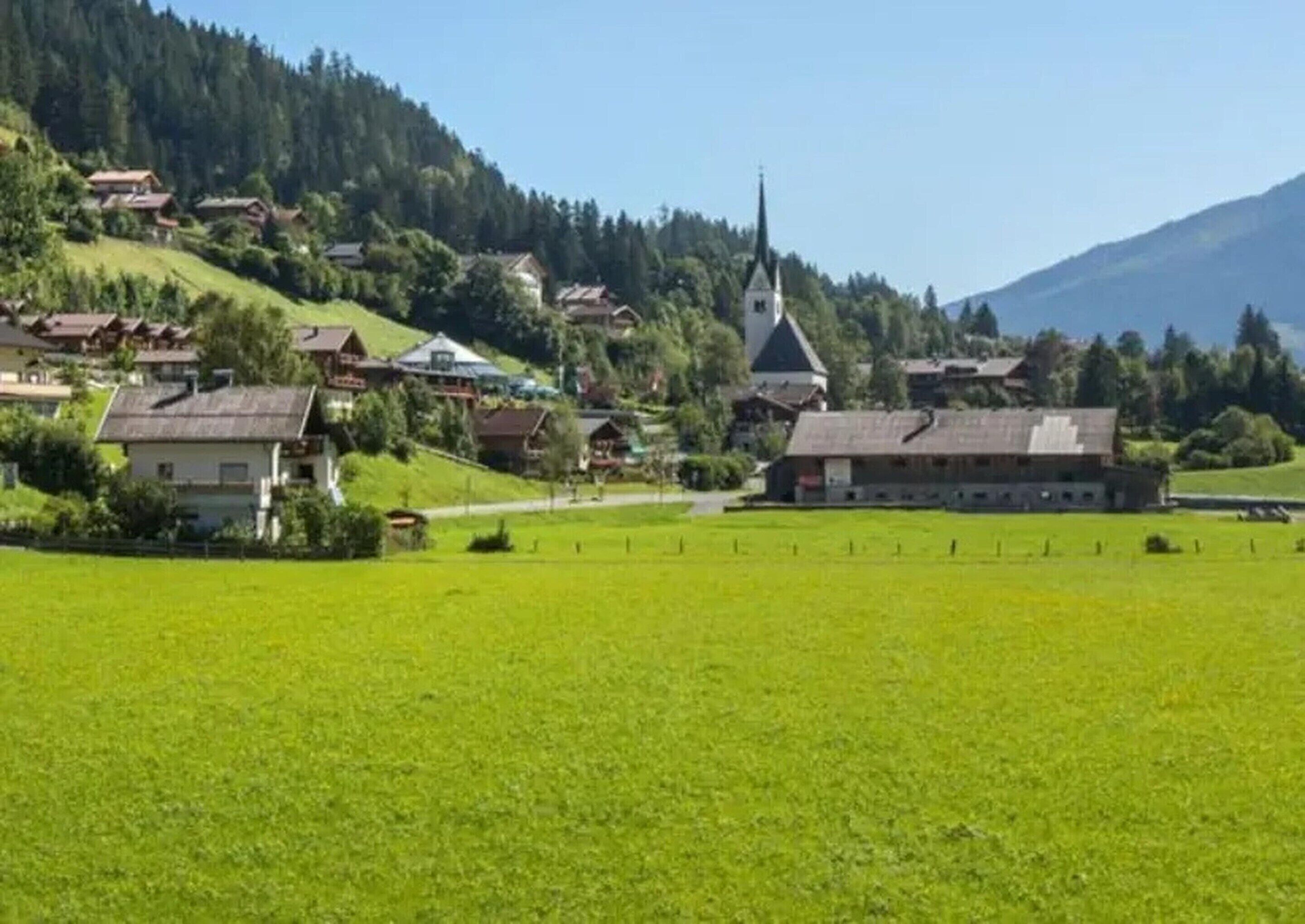 En landlig landsby med huse, en kirke og en stor åben mark.