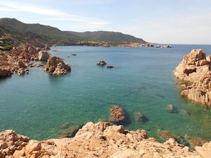 Un paysage côtier caractérisé par un terrain rocheux et des eaux d’un bleu limpide.