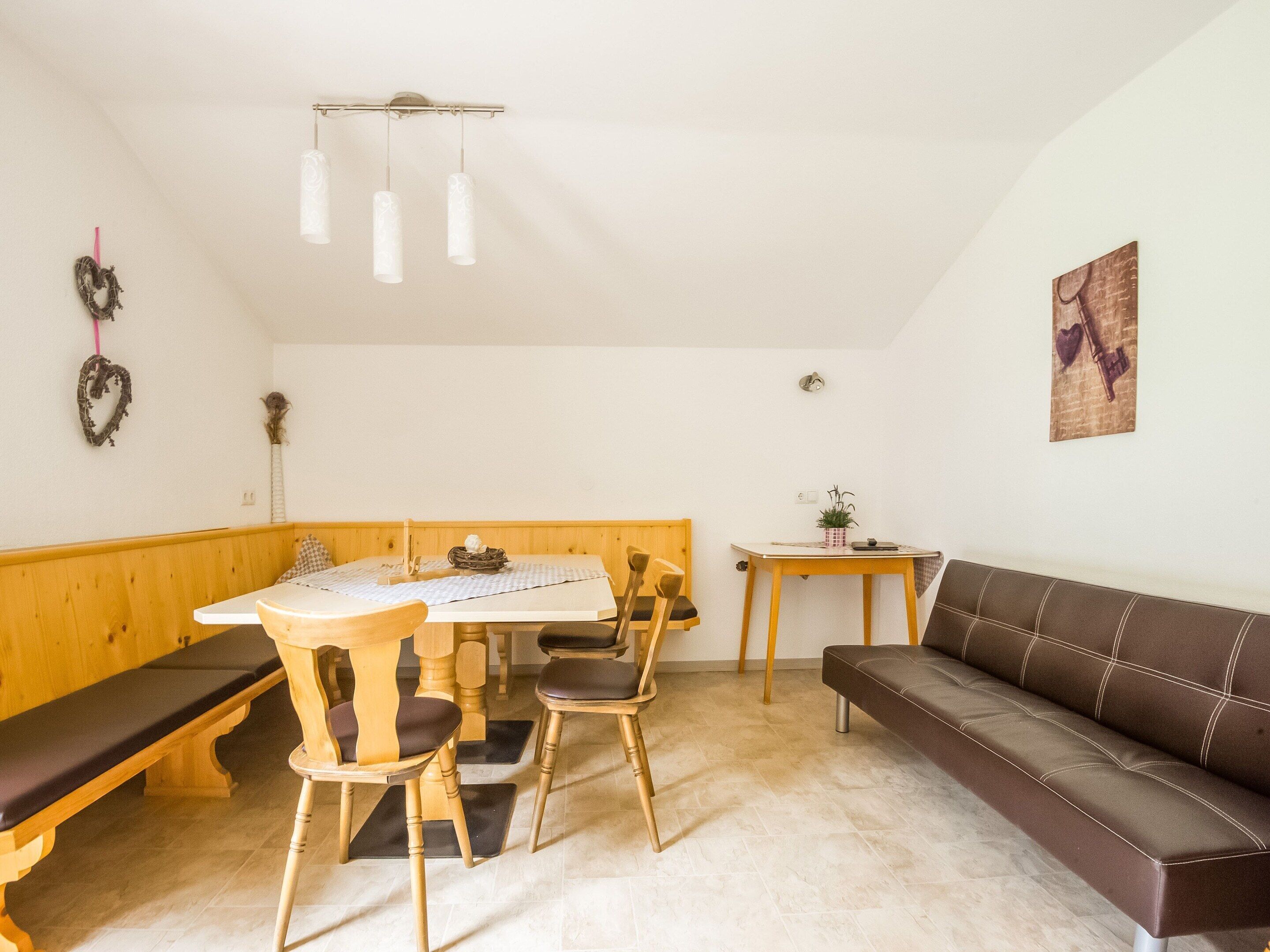 A cozy dining area with a wooden bench, a table, and chairs.