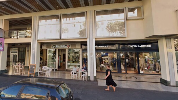 Un immeuble abritant un café appelé « CAFFETTIAM » et un magasin appelé « DAVID SADDLER ».
