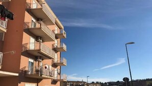 A multi-story residential building with balconies, air conditioning units, and a clear blue sky. - Belvilla by OYO Tenute D'angelo (Agrigento)