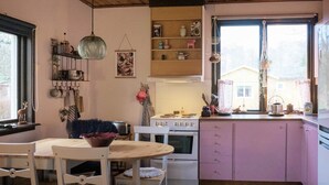 A kitchen with wooden cabinets, a stove, and a dining table with chairs. - 4 Person Holiday Home in Tibro (Tibro)