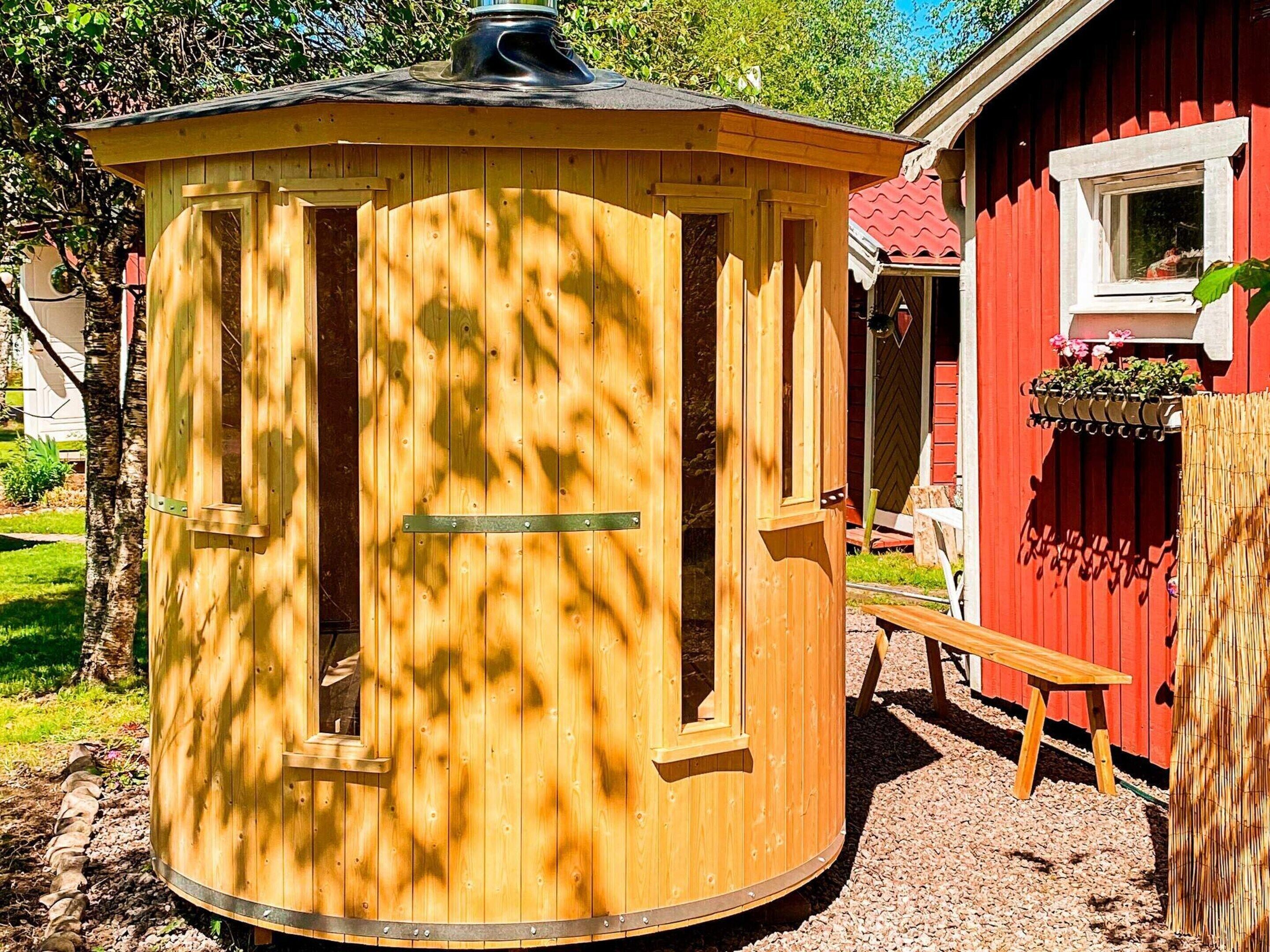 A wooden structure with a circular shape, a door, and a window.