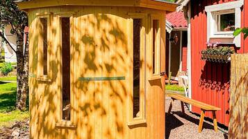 A wooden structure with a circular shape, a door, and a window.