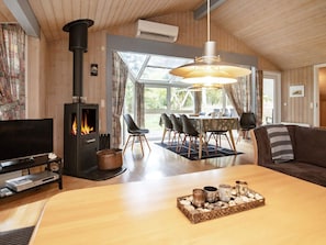 Ein gemütliches Wohnzimmer mit Kamin, Essbereich und einer Couch.