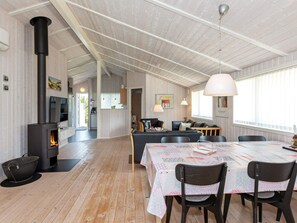 A spacious living area with a fireplace, a dining table, and a sofa. - Holiday Home in LÃ¸kken (Lokken)