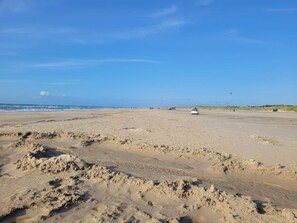 A wide sandy beach with a clear sky and a vehicle in the distance. - Holiday Home in LÃ¸kken (Lokken)
