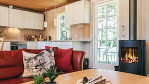 Un salón acogedor con sofá, chimenea y una mesa de comedor con un plato de comida.