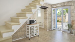 A staircase with a microwave on a cart, a stone wall, and a door leading outside. - Modern Holiday Home With Jacuzzi (Medulin)