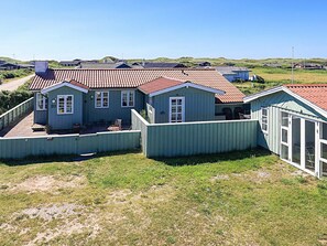 A coastal house with a red-tiled roof, a fenced yard, and a clear view of the sea. - Holiday Home in LÃ¸kken (Lokken)