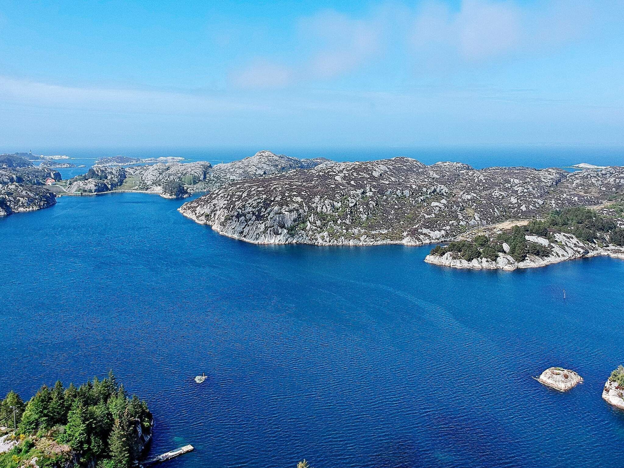 A coastal landscape with rocky terrain and clear blue waters.