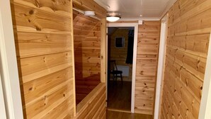 A wooden interior hallway with a door leading to a room with a chair and a small table. - 6 Person Holiday Home in Brandasund (Bomlo)