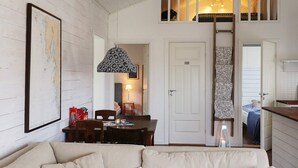 A cozy room with a dining area, a sofa, and a staircase leading to an upper level. - 5 Person Holiday Home in Varobacka (Väröbacka)