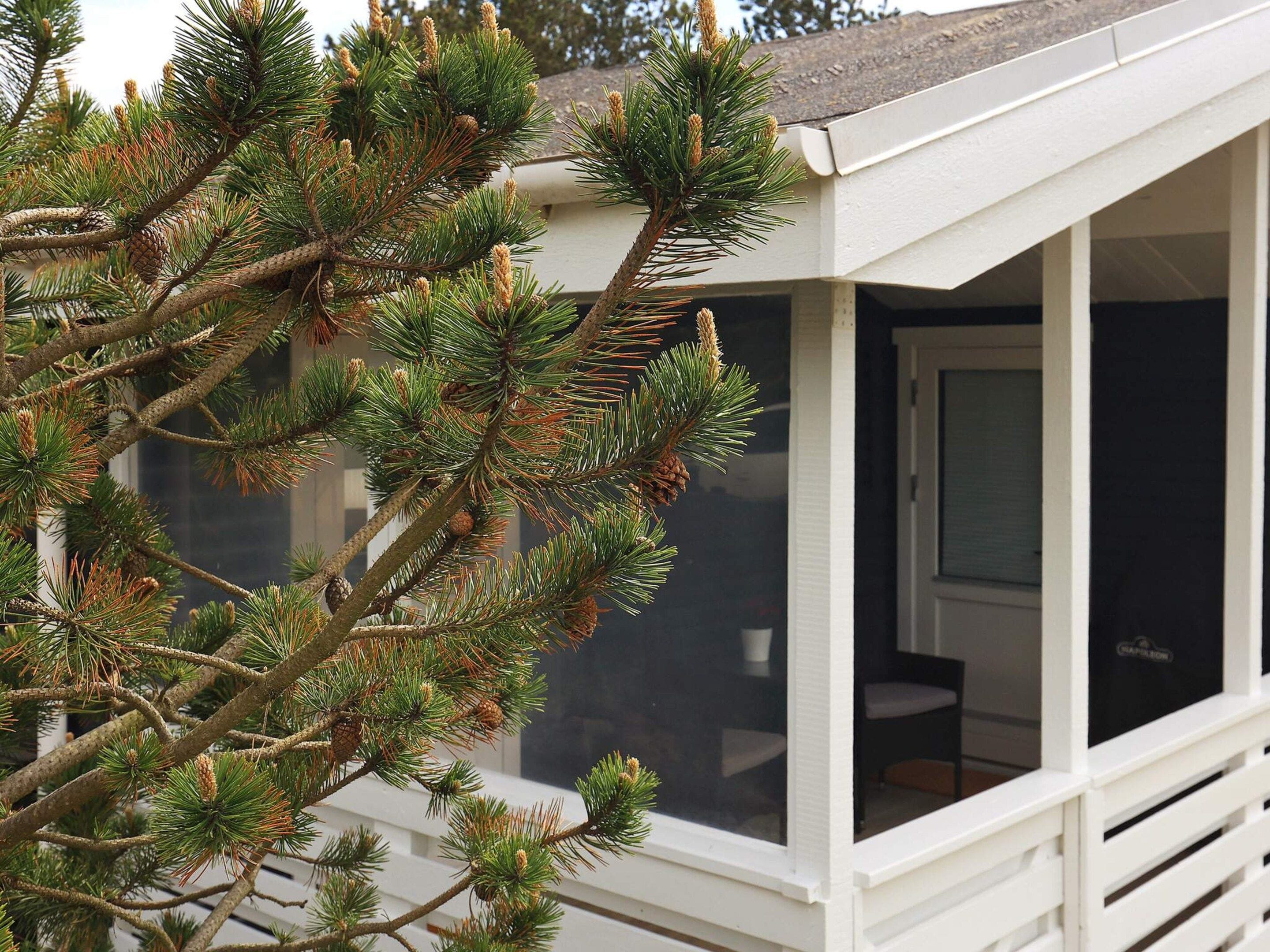 A white building with a covered porch and a window.