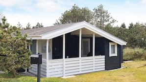 A small, single-story cabin with a porch and a door leading inside. - 4 Person Holiday Home in Thisted (Thisted)