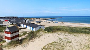 A coastal village with buildings, boats, and a sandy beach. - 4 Person Holiday Home in Thisted (Thisted)