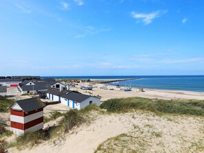 Un village côtier avec des bâtiments, des bateaux et une plage de sable.