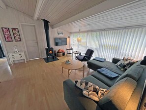 Una sala de estar acogedora con chimenea, un sofá, una televisión y un comedor.