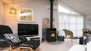 A modern living room with a fireplace, a television, and comfortable seating.