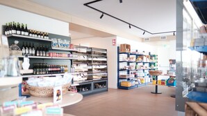 Un grand magasin spacieux, avec des étagères remplies de divers produits, notamment des bouteilles de vin et des produits emballés.