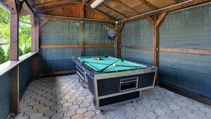 A pool table in a wooden room with a dartboard and a window. - Holiday Home in Lindar With Pool (Pazin)