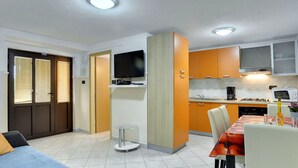 A compact living space with a kitchenette, a dining area, and a seating area with a sofa and chairs. - Holiday Home in Lindar With Pool (Pazin)