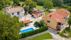 A residential area with multiple houses, a swimming pool, and a lush green landscape. - Holiday Home in Lindar With Pool (Pazin)