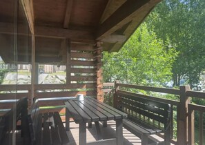 An outdoor wooden deck with benches and a table, overlooking a natural landscape. - Chalet Retreat With Sauna in Wald (Wald im Pinzgau)