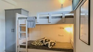 A bunk bed with a ladder, a pillow, a cabinet, and a wall-mounted light fixture. - Chalet Retreat With Sauna in Wald (Wald im Pinzgau)