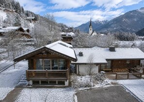 A wooden cabin with a balcony, surrounded by snow-covered trees and mountains in the background. - Chalet Retreat With Sauna in Wald (Wald im Pinzgau)