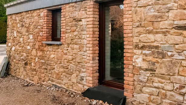 Un edificio de piedra con una ventana y una puerta.