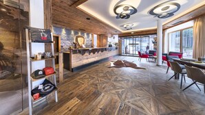 Un intérieur moderne avec un plancher en bois, un bar central et un espace aménagé pour s’asseoir.