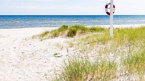 A beach with a lifeguard sign. - Holiday Home in Sæby (Sæby)