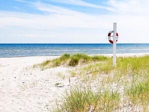 A beach with a lifeguard sign. - Holiday Home in Sæby (Sæby)