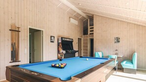 A pool table with a blue felt surface, a pool cue rack, and a pool table with a wooden frame. - Holiday Home in Sæby (Sæby)