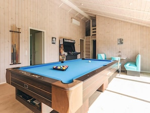 A pool table with a blue felt surface, a pool cue rack, and a pool table with a wooden frame. - Holiday Home in Sæby (Sæby)