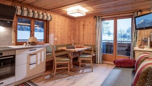 L’intérieur d’un chalet en bois comprend un coin repas, une cuisine et un espace salon confortable.