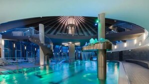 An indoor swimming pool with a central water feature and a modern architectural design. - Cozy Chalet with 4 Bathrooms near Königsleiten (Wald im Pinzgau)