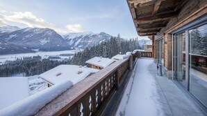 A wooden balcony with a snow-covered roof overlooking a mountainous landscape. - Nationalpark Chalet Hohe Warte (Neukirchen am Grossvenediger)
