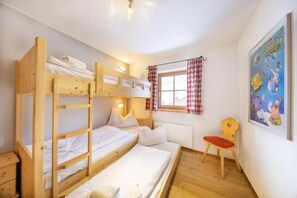 A bunk bed room with a window, a radiator, a chair, and a poster on the wall. - Cozy Chalet with Sauna near Königsleiten (Wald im Pinzgau)