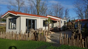 A single-story house with a red roof, a front porch, and a wooden fence. - Chalet in Goedereede Near North Sea Beach (Goedereede)