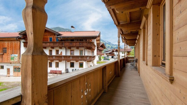 Ein Holzbalkon mit Blick auf traditionelle Häuser und Berge.