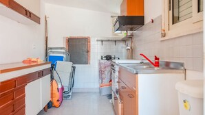 A compact kitchen with a stove, sink, and cabinets. - Belvilla by OYO Villa Amos (Noto)