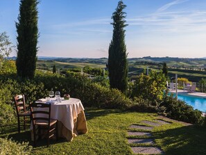 A dining table set outdoors with a view of a pool and hills. - Vacation Home in Tuscany With Pool (Vinci)